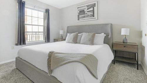 a white bedroom with a large bed and a window at Landing Modern Apartment with Amazing Amenities (ID7807X89) in Wichita