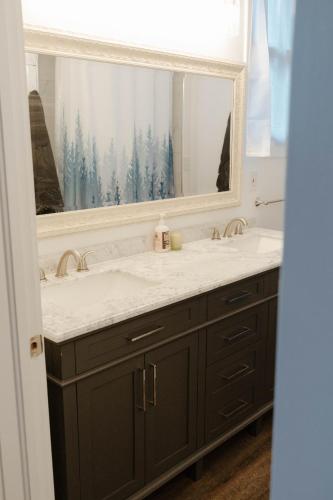 a bathroom with a sink and a large mirror at Central Tacoma Triplex in Tacoma