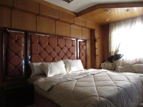 a bedroom with a large bed with a wooden headboard at The guest house in Alexandria