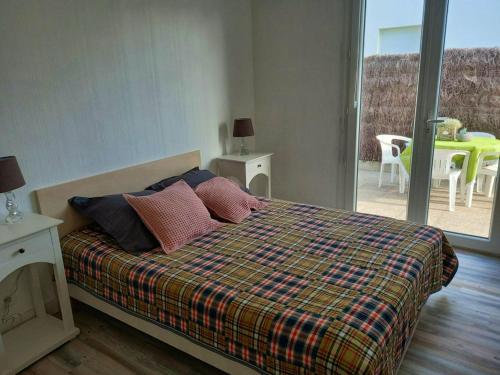 - une chambre avec un lit et une couette en tresses dans l'établissement Maison charmante avec grand jardin - St-Pierre-Quiberon, à Saint-Pierre-Quiberon