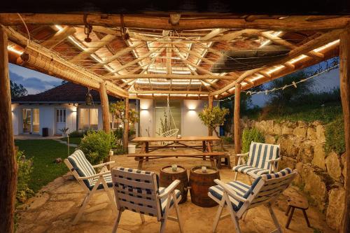 a wooden pergola with chairs and a picnic table at Vila Julija 