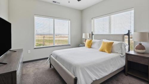 1 dormitorio blanco con 1 cama y 2 ventanas en Landing Modern Apartment with Amazing Amenities (ID8800X61) 