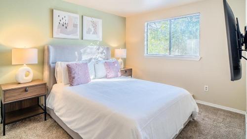 een slaapkamer met een wit bed en een raam bij Landing Modern Apartment with Amazing Amenities (ID8473X04) in Redmond