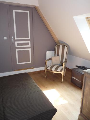 Cette chambre comprend une chaise et une porte coulissante. dans l'établissement Gite 