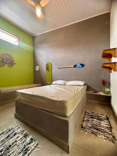 a bedroom with a bed with a baseball bat on the wall at Sossego do Perequê in Ubatuba