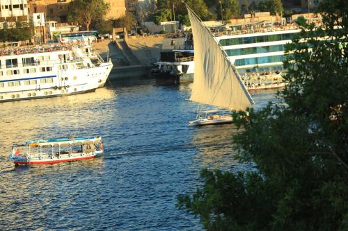 two boats in a river with a sail boat at Crystala guest house in Aswan
