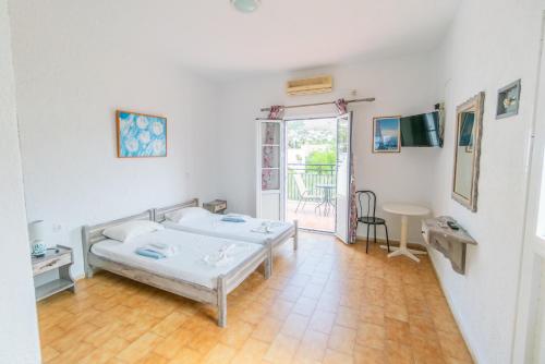 Habitación blanca con cama y mesa en NORMA'S VILLAGE en Kalymnos