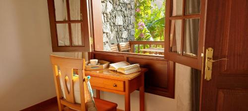 a wooden desk with a chair next to a window at Casa Rural Tía Rita La Gomera in Vallehermoso