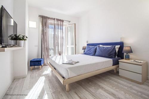 a bedroom with a bed with blue pillows and a window at Gardenia Luxury in Palau