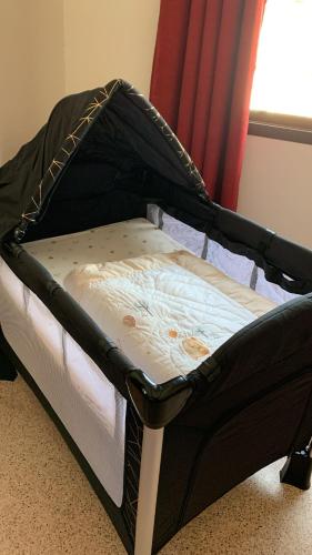 a small bed with a black and white mattress at Arabian Nights Nook in Muscat