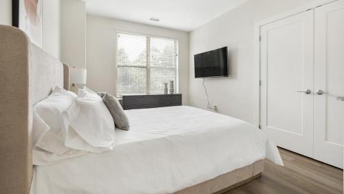 Habitación blanca con cama y TV en Landing Modern Apartment with Amazing Amenities (ID1971X10) en Bala-Cynwyd