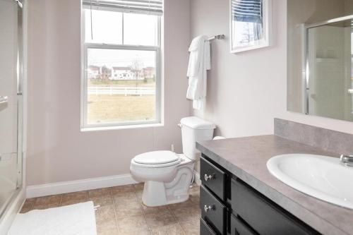 baño con aseo y lavabo y ventana en Landing Modern Apartment with Amazing Amenities (ID5458) en Lewis Center
