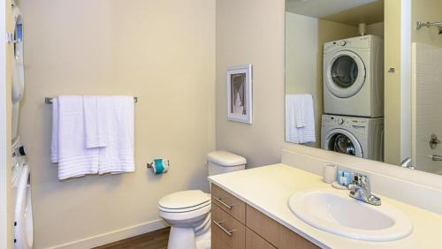 a bathroom with a sink and a washing machine at Landing Modern Apartment with Amazing Amenities (ID8426X91) in Tacoma