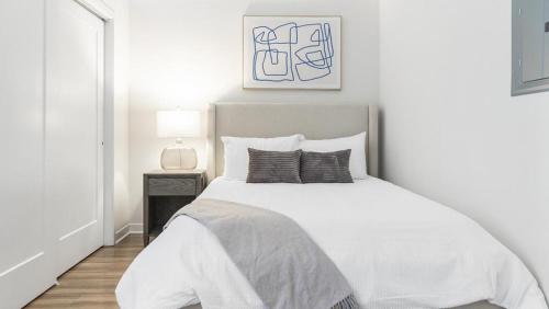 - une chambre blanche avec un grand lit blanc dans l'établissement Landing Modern Apartment with Amazing Amenities (ID6631X57), à Overland Park