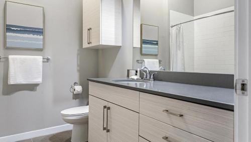 La salle de bains blanche est pourvue d'un lavabo et de toilettes. dans l'établissement Landing Modern Apartment with Amazing Amenities (ID6631X57), à Overland Park