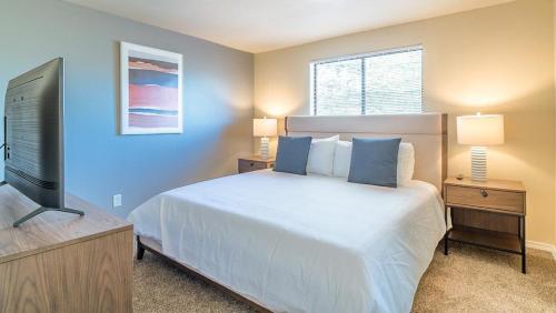 een slaapkamer met een bed en een flatscreen-tv bij Landing Modern Apartment with Amazing Amenities (ID8472X99) in Redmond