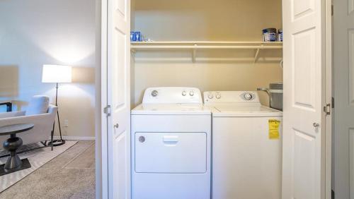 een kleine wasruimte met een wasmachine en droger bij Landing Modern Apartment with Amazing Amenities (ID8472X99) in Redmond