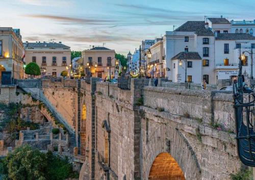an old stone bridge in a city with buildings at Apartamento Espinel 47 in Ronda