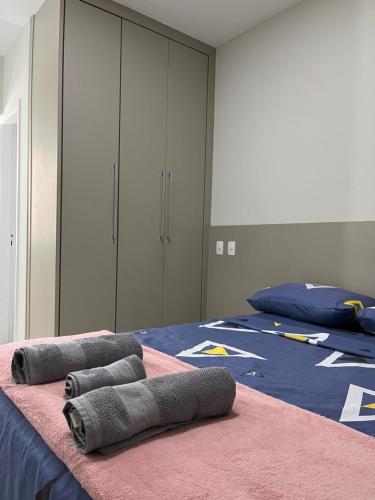 1 dormitorio con 2 camas y toallas grises. en Ocean flat com vista pro mar 404 en Vila Velha