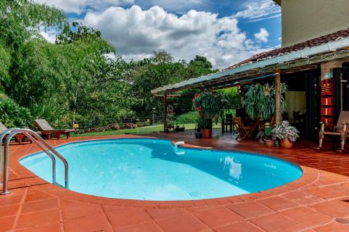 基姆巴亞的住宿－Villa Alegre - Fincas Panaca，一个带房子的庭院中的游泳池