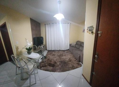a living room with a table and a couch at Estadia da Josi in Balneário Camboriú