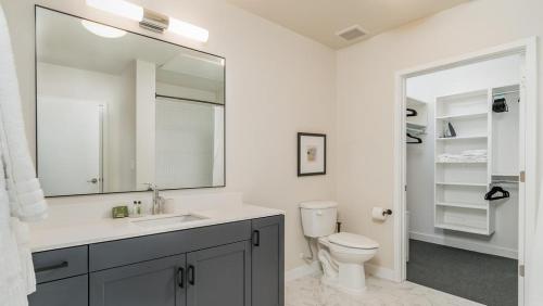 a bathroom with a toilet and a sink and a mirror at Landing Modern Apartment with Amazing Amenities (ID6454X40) in Salt Lake City