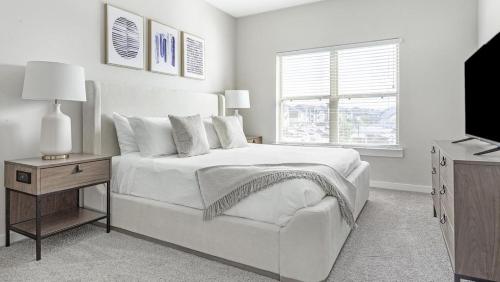a white bedroom with a bed and a television at Landing Modern Apartment with Amazing Amenities (ID1231X478) in San Marcos