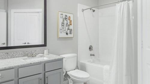 a white bathroom with a toilet and a shower at Landing Modern Apartment with Amazing Amenities (ID1231X478) in San Marcos