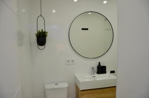 a white bathroom with a sink and a mirror at Benalbeach Zafiro by C&N in Benalmádena