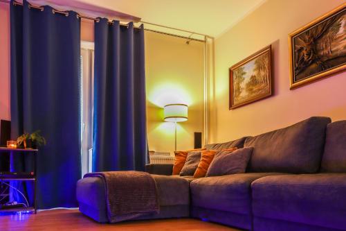 sala de estar con sofá y cortinas azules en Agroturystyka Karpińscy, en Wizna
