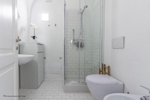 a white bathroom with a toilet and a shower at Gardenia Luxury in Palau