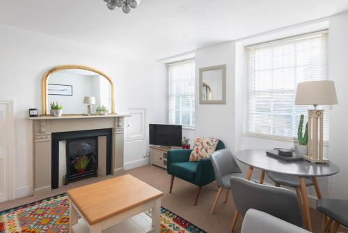 a living room with a fireplace and a table and chairs at Parade Watch in Bath