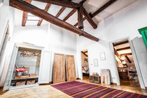 a room with white walls and wooden beams at Loft overlooking the old town . in Feltre