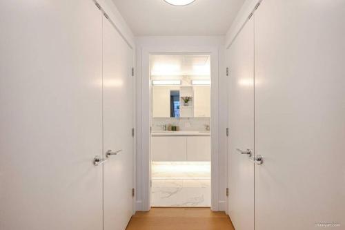 a hallway with two white doors and a sink at new apartment 3 bedrooms in Richmond