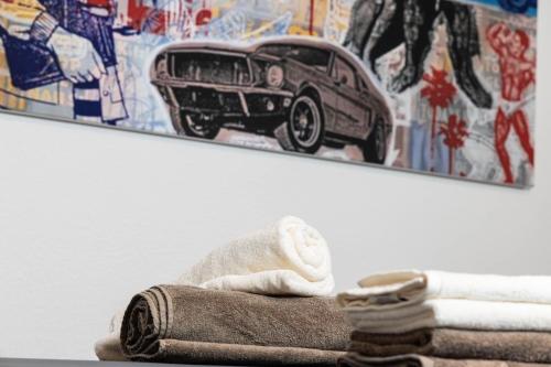 a bathroom with a towel and a picture of a car at Airstream Guesthouse in Basel