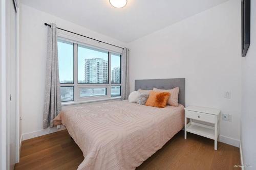 a bedroom with a bed with a large window at new apartment 3 bedrooms in Richmond