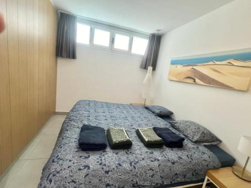 a bedroom with a bed with two remotes on it at Apartment at bronze playa hotel in San Bartolomé de Tirajana