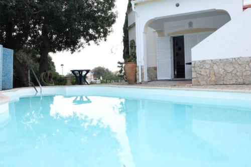a swimming pool in front of a house at Alcaria Pool House in Altura