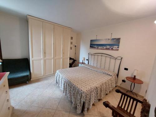 a bedroom with a bed and a chair at Casa Bianca in Pietrasanta
