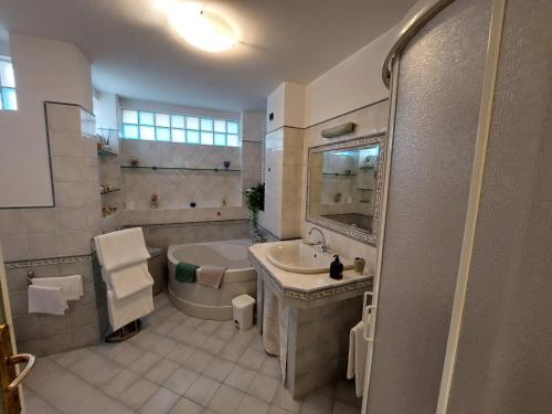 a large bathroom with a tub and a sink and a tub at Casa Bianca in Pietrasanta