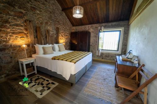 una camera con un letto in una stanza con pareti in pietra di Estancia Los Plátanos a Valentines