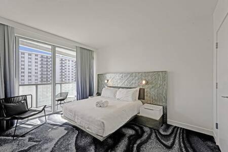 Cette chambre comprend un lit et une grande fenêtre. dans l'établissement WVR Vacation Residences 709, à Fort Lauderdale