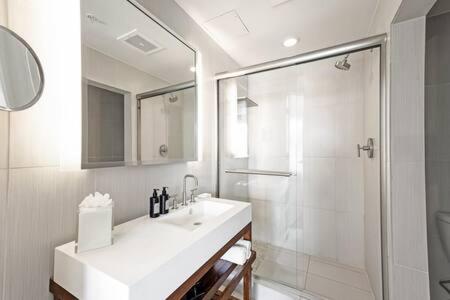 uma casa de banho branca com um lavatório e um chuveiro em WVR Vacation Residences 709 em Fort Lauderdale