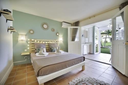 ein Schlafzimmer mit einem großen Bett mit Lampen an der Wand in der Unterkunft Le Pti' Zandoli Anse des Rochers in Saint-François