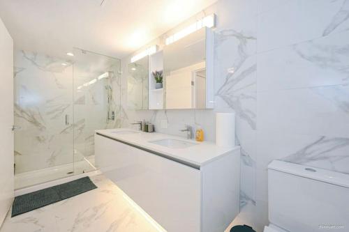 a white bathroom with a sink and a shower at new apartment 3 bedrooms in Richmond