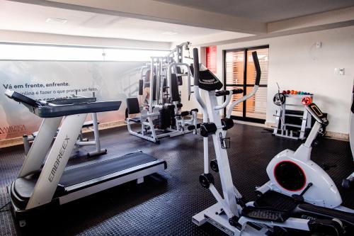 a room with a gym with tread machines at Athenas Suites By BnbHost in Salvador