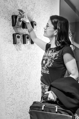 a woman standing with a suitcase and holding a cup at La Sofia Apart & Wines in Mendoza