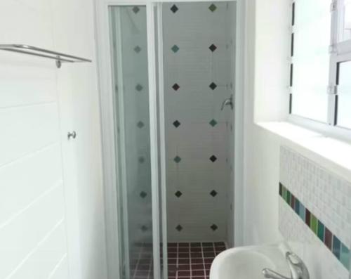ein Bad mit einer Dusche und einer Glastür in der Unterkunft Cavendish Suite Bachelor in Kapstadt