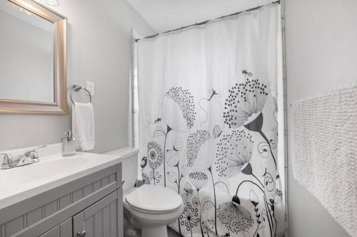 a bathroom with a toilet and a shower curtain at Cozy King Suite Near Broad! in Memphis