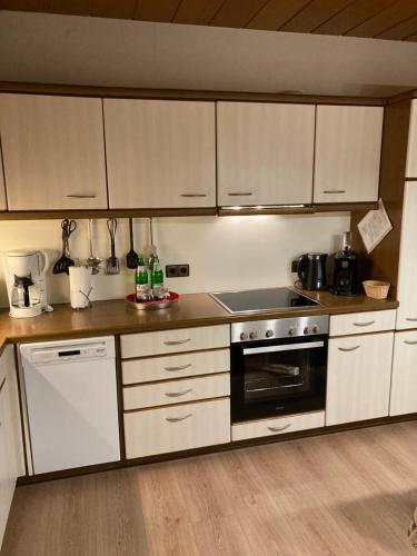 a kitchen with white cabinets and a stove top oven at Ferienwohnung am Wiehengebirge in Hüllhorst
